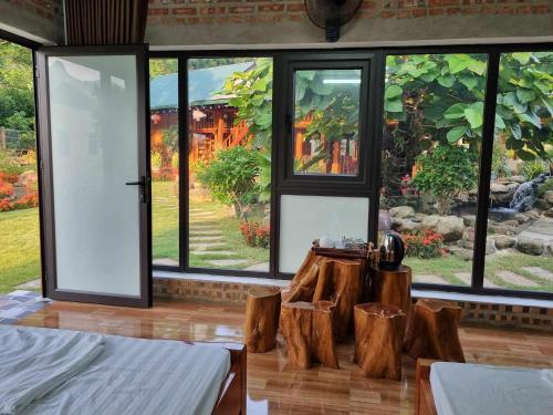 a room with large windows and a room with logs at Trường Anh Homestay Hà Giang in Ha Giang