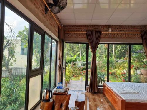 a room with large windows and a bed and a room with at Trường Anh Homestay Hà Giang in Ha Giang