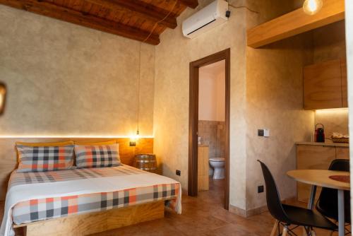 1 dormitorio con cama, mesa y cocina en L'Antico Vigneto, en Marino