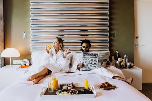 two people sitting in bed reading a newspaper at W Bellevue in Bellevue