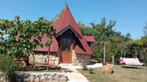 a small stone house with a red roof at Domaćinstvo Peković in Danilovgrad
