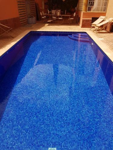 a large blue swimming pool with blue water at Hôtel Riad Airport Marrakech in Marrakech