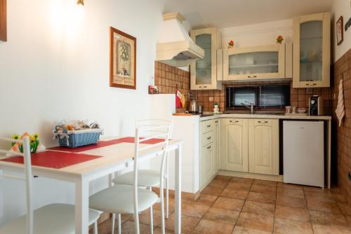 a kitchen with white cabinets and a table and chairs at L'Antico Vigneto in Marino
