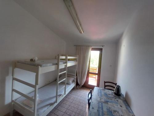 Pokój z 2 łóżkami piętrowymi, stołem i oknem w obiekcie Studio-app Iva, balcony with sea view - 50 m from beach w mieście Pag