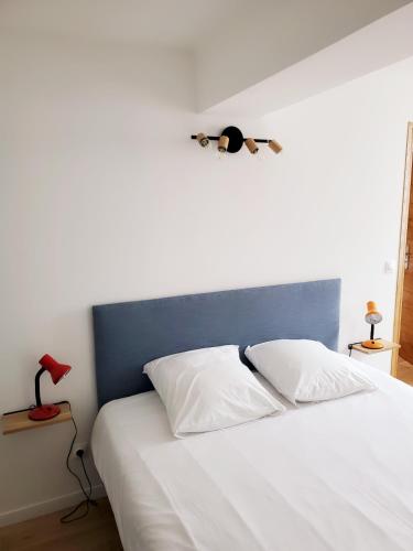 - une chambre avec un lit blanc et une tête de lit bleue dans l'établissement Market Appart 44m2 - 1 chambre - près du Marché, à La Rochelle
