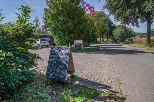 un panneau assis sur le côté d'une route dans l'établissement Buitengewoon Overnachten, à Terheijden