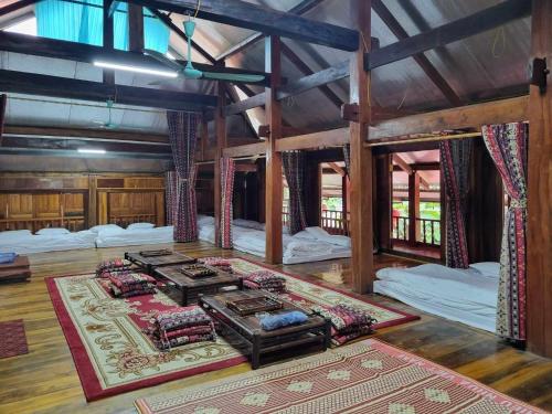 a large room with four beds and a rug at Trường Anh Homestay Bản Tùy Hà Giang in Ha Giang