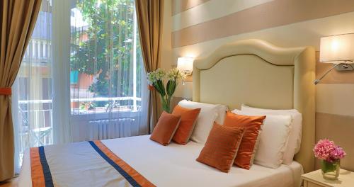 a bedroom with a bed with orange and white pillows at Hotel Tigullio Et De Milan in Santa Margherita Ligure