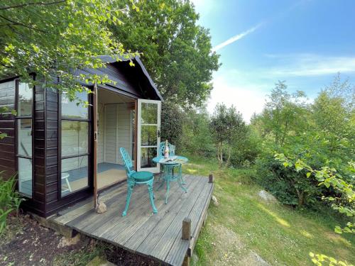 a tiny house with a table and chairs on a deck at Pass the Keys Beautiful 2BR Beach Lodge Set In Stunning Gardens in Dalbeattie