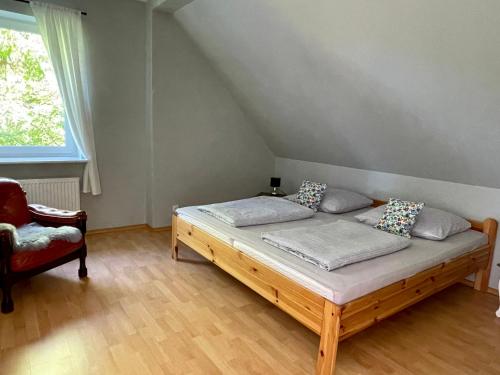 a bedroom with a wooden bed and a chair at Sielski wypoczynek blisko Kołobrzegu in Dębogard