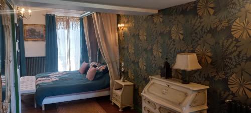 a bedroom with a bed with blue sheets and a window at Villa Hortensia in Bagnères-de-Bigorre