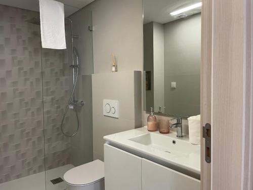 ein Badezimmer mit einem weißen Waschbecken und einer Dusche in der Unterkunft The Pearl of Seixal in Seixal