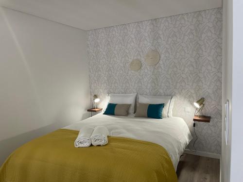 1 dormitorio con 1 cama grande y 2 toallas. en The Pearl of Seixal, en Seixal