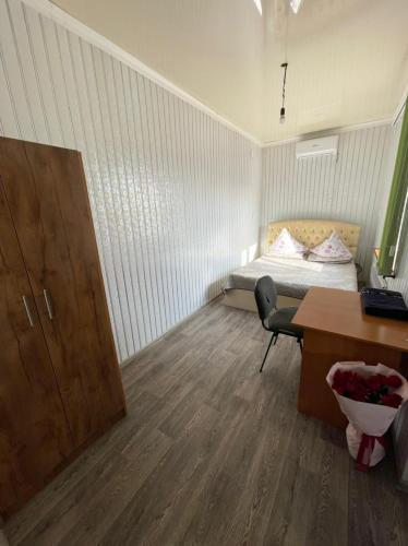 a small room with a bed and a desk at Guest House 777 in Türkistan
