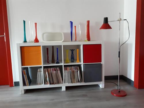 une étagère avec des vases et une lampe de chevet dans l'établissement Les Gites du 74 R Le Vintage, à Senones