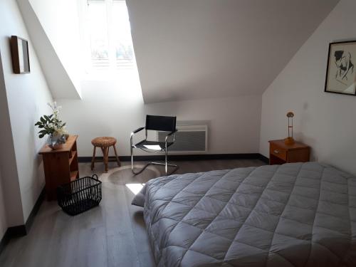 une chambre avec un grand lit et une chaise dans l'établissement Les Gites du 74 R Le Vintage, à Senones
