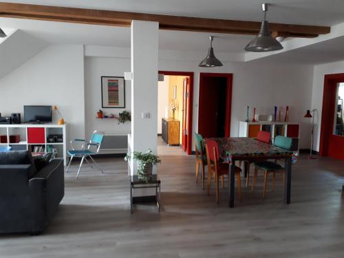 un salon et une salle à manger avec une table et des chaises dans l'établissement Les Gites du 74 R Le Vintage, à Senones