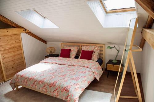 una camera da letto con un letto in mansarda con lucernari di Appartement cosy de 60m2 au centre ville d’embrun a Embrun