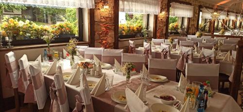 a dining room with white tables and white chairs at Pensjonat Melaxa in Węgierska Górka