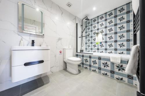 倫敦的住宿－7 - West London Brand New Loft，浴室配有卫生间、盥洗盆和浴缸。