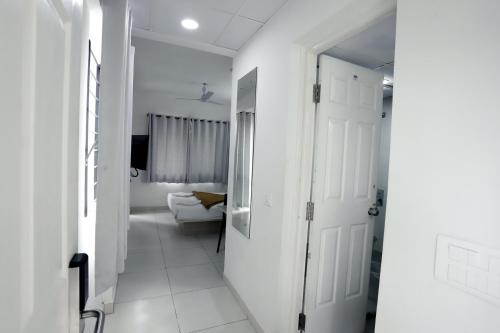 a hallway with white walls and a white door at Hotel Gurudev Residency in Bangalore