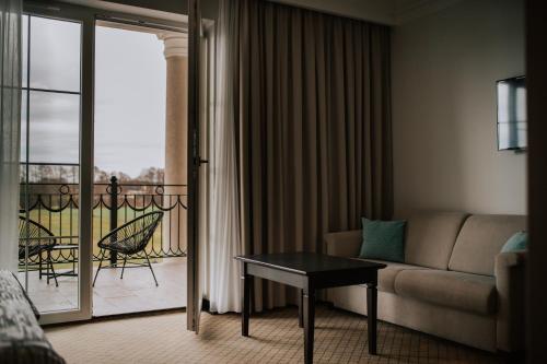 a living room with a couch and a balcony at Hotel Toscania in Włoszakowice