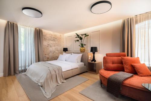 een slaapkamer met een bed, een bank en een stoel bij Golden Gate Luxury Rooms - Unique UNESCO Location in Split