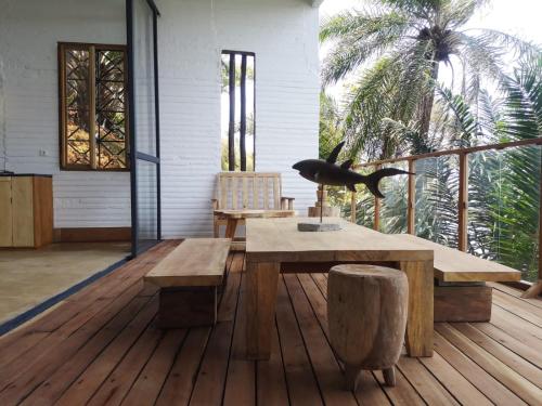 Habitación con terraza de madera con mesa y bancos. en Takina house en Santana