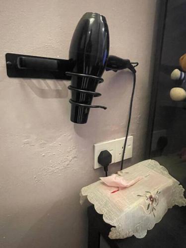 a black phone hanging on a wall next to a table at Cozy Stay At Raintown Taiping in Kamunting