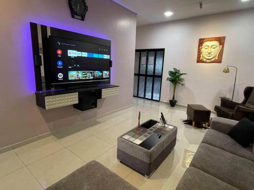 a living room with a large flat screen tv at Cozy Stay At Raintown Taiping in Kamunting