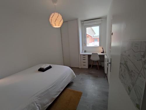 1 dormitorio con cama, ventana y escritorio en Appartement Terrasse Sud Dernier étage + Parking, en Le Havre