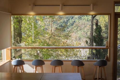 ventana grande en una habitación con mesa y taburetes en Mountain Lodge, en Taimali