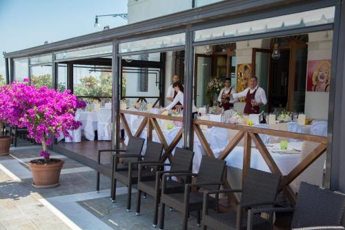 un restaurante con mesas y sillas blancas y gente de pie en Antica Dogana en Cavallino-Treporti