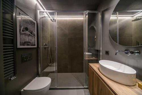 uma casa de banho com um chuveiro, um lavatório e um WC. em Eleven Luxury Suite em Gênova