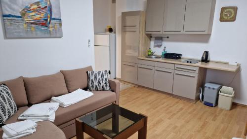 een woonkamer met een bank en een keuken bij Apartments Miro Omišalj in Omišalj
