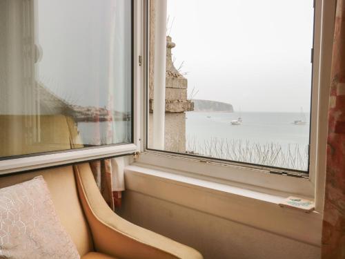 una ventana con vistas al agua y a un barco en Bay View, en Swanage