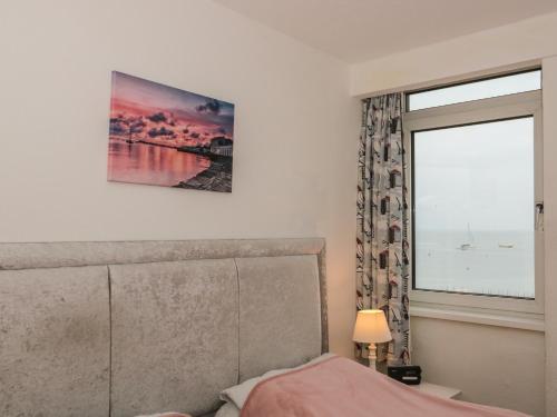 een slaapkamer met een raam en een bed met een hoofdeinde bij Bay View in Swanage