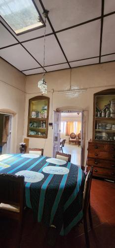 a dining room with a table with a striped table cloth at Heath Cote in Ooty