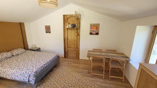 a bedroom with a bed and a table and a desk at Ferme de Lacassagne in Vazerac