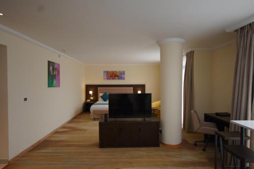 a hotel room with a bed and a flat screen tv at Best Western Premier Dynasty in Addis Ababa