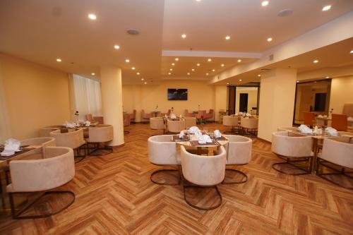 a restaurant with white chairs and tables in a room at Best Western Premier Dynasty in Addis Ababa