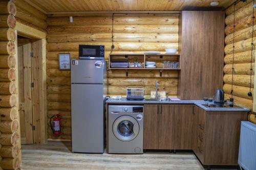 a kitchen with a refrigerator and a washing machine at Eco House Borjomi in Borjomi