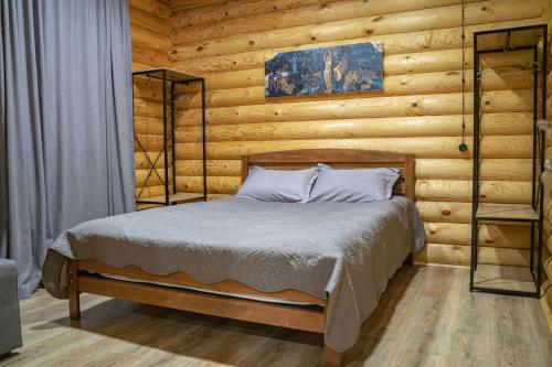 1 dormitorio con 1 cama en una pared de madera en Eco House Borjomi en Borjomi