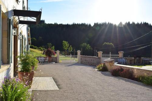 a driveway of a house with the sun in the background at Le Domaine de la Source in Chauffailles