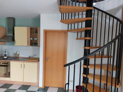 a kitchen with a spiral staircase in a house at Ferienwohnung in Worms in Worms