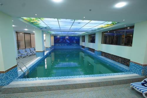 a swimming pool in a building with blue tiles at Best Western Premier Dynasty in Addis Ababa