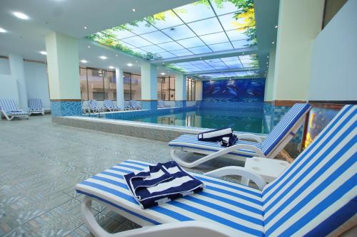 a pool with two lounge chairs and a swimming pool at Best Western Premier Dynasty in Addis Ababa