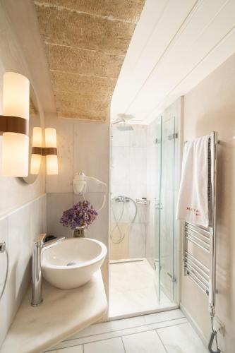 a bathroom with a sink and a shower at Bastione Malvasia Hotel (ex New Malvasia) in Monemvasia