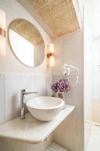 a bathroom with a bowl sink and a mirror at Bastione Malvasia Hotel (ex New Malvasia) in Monemvasia