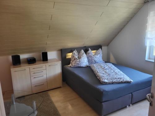 a small bedroom with a blue bed in a attic at Gästezimmer im bewohnten EFH mit Pool und Garten in Ziltendorf